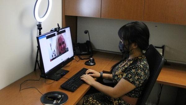 Woman sitting at a desk using a computer to try out the interview equipment at careers services